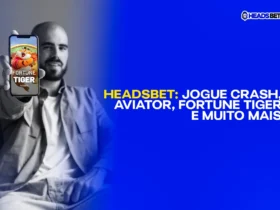 imagem em preto e branco com homem sentado e sorrindo apontando o celular em direção da tela com uma imagem colorida do jogo de cassino fortune tiger. Crash games na Headsbet: aviator, fortune tiger.